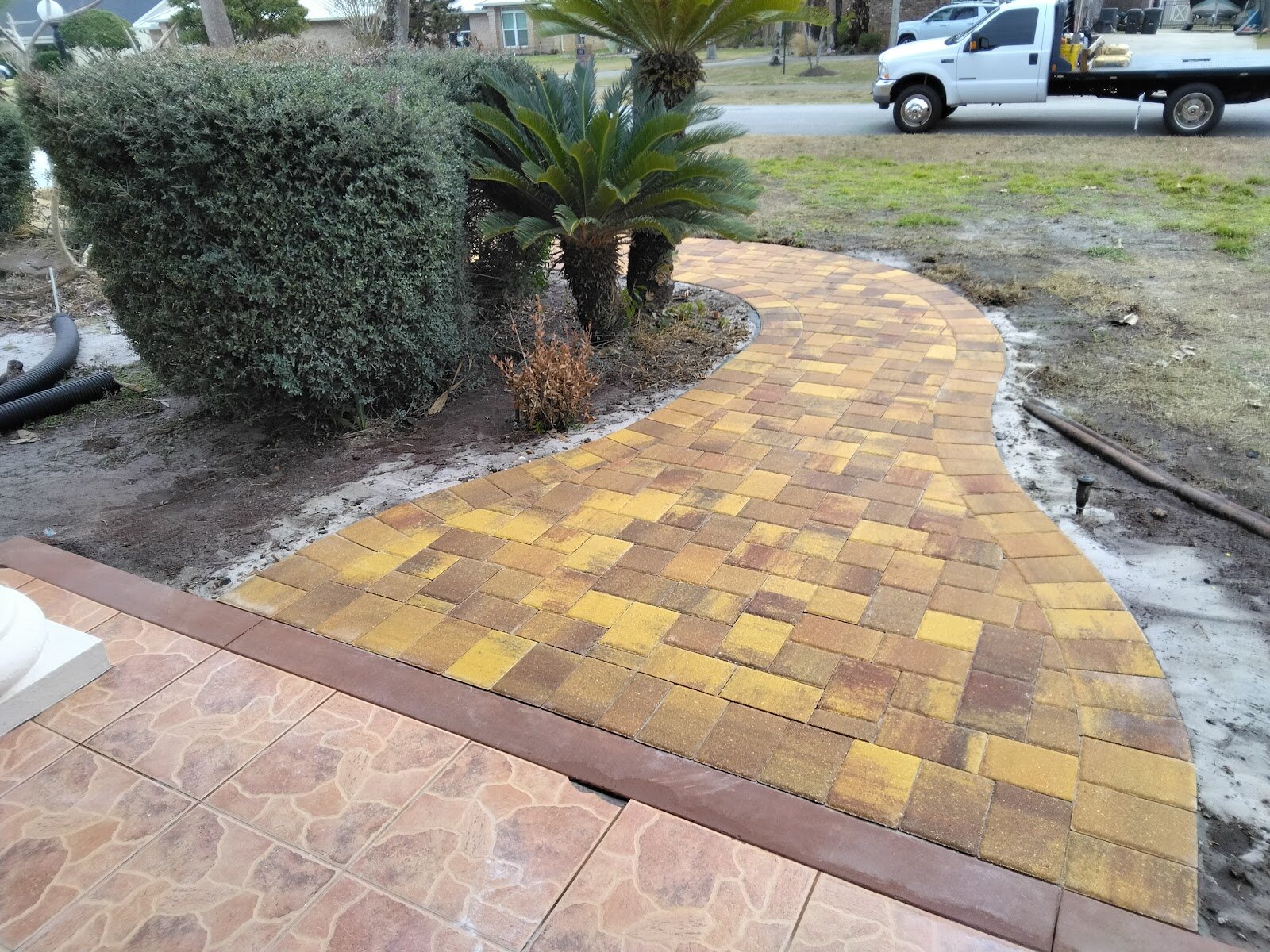 Curved golden brick paver walkway with a tile border, an Expert Stone & Brick Pavers project in DeLand